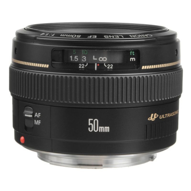 در تصویر، لنز Canon EF 50mm f/1.4 USM با بدنه مشکی کلاسیک و طراحی جمع‌وجور دیده می‌شود. حلقه فوکوس نرم و بزرگ به کاربر امکان کنترل دقیق فوکوس را می‌دهد.